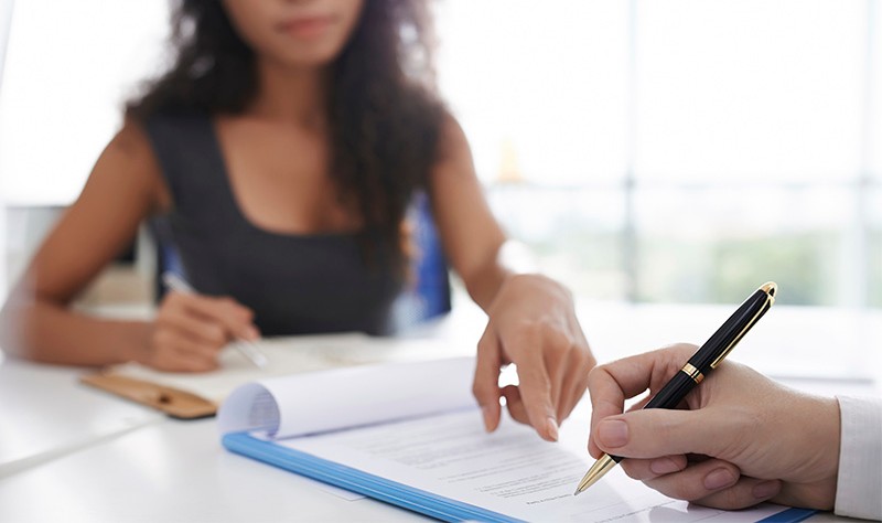 cropped image of a woman asking for signature from a man