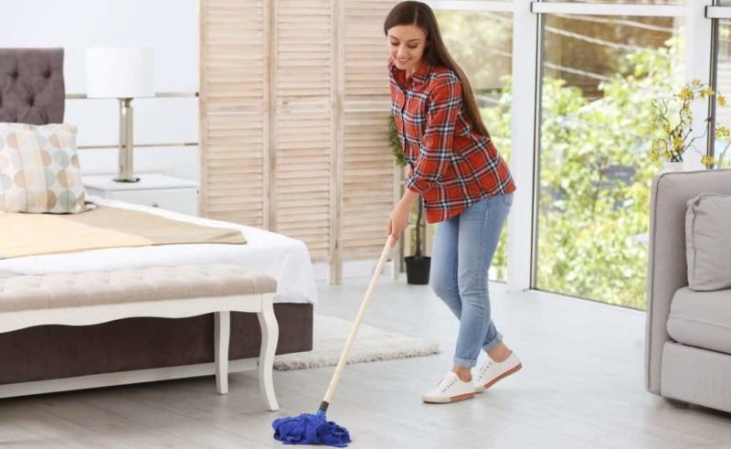young woman sprucing up a bedroom