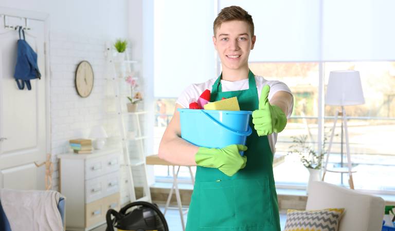 Man in green dress holding a blue basket and thumps up