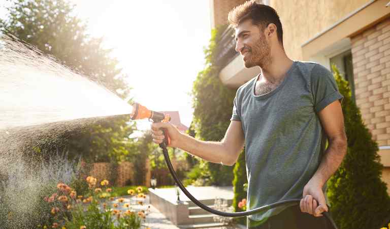 Young boy using pressure water to clean his exterior.