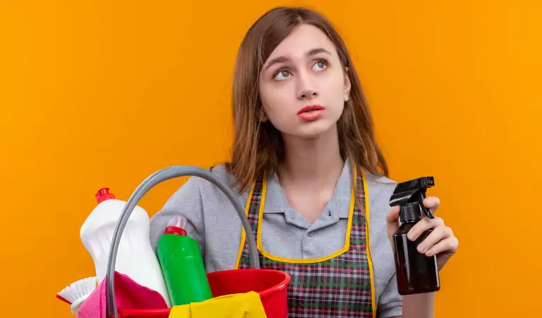 you woman with some cleaning supplies looking confused