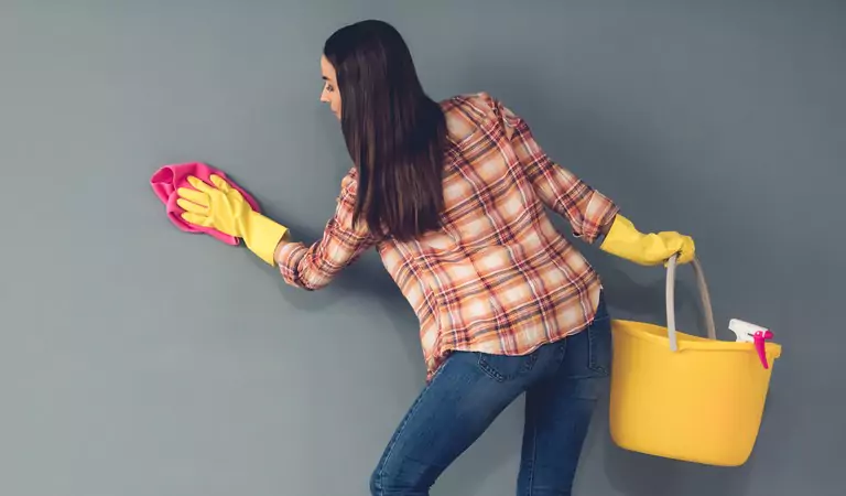 young woman cleaning the walls