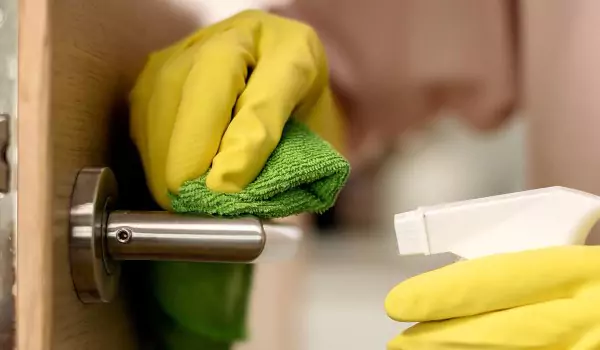 cropped picture of a person cleaning the door knob