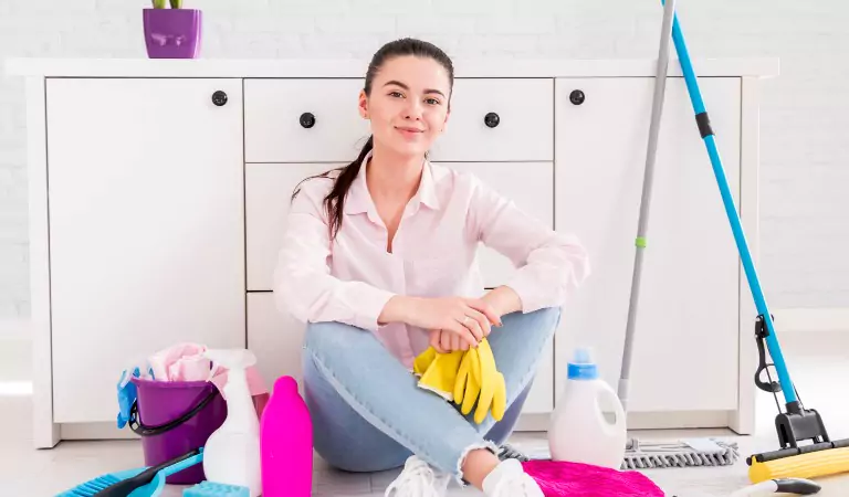 woman with some cleaning supplies sitting on the floor