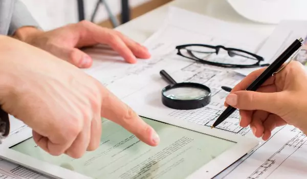 cropped picture of two persons checking a report