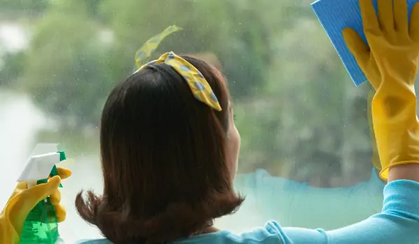 woman cleaning a window glass