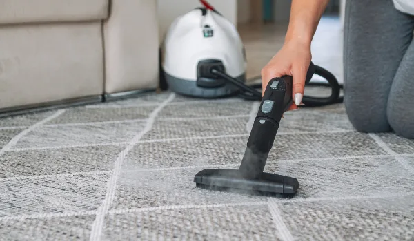 Woman cleaning carpet with a steam cleaner