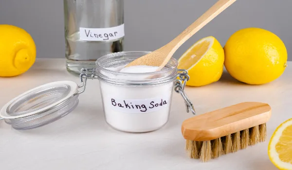 Baking soda vinegar and lemon on a gray background