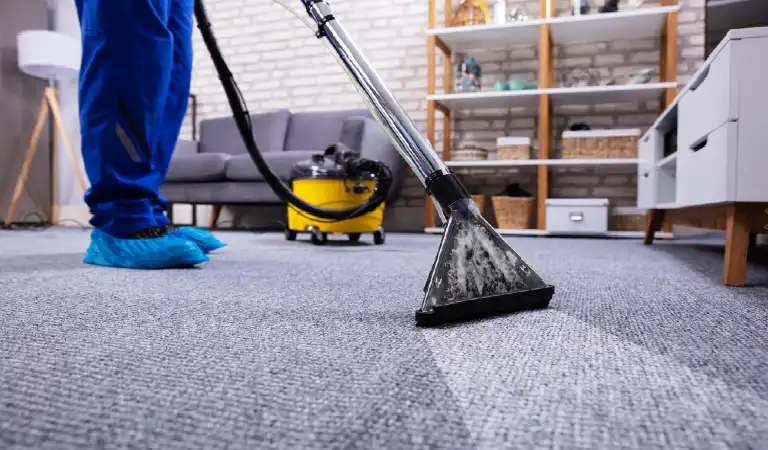 Person cleaning carpet with vacuum cleaner