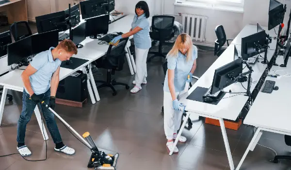 Cleans floor group of workers clean modern office together at daytime