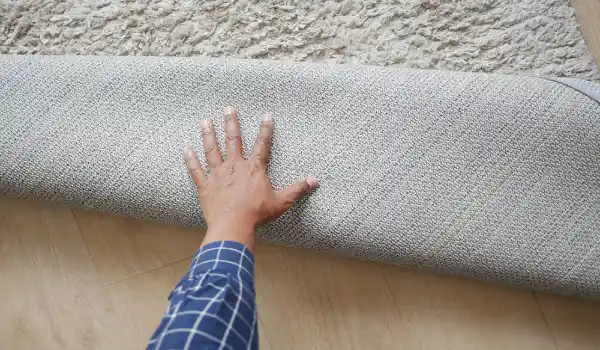 Men hand rolling out rug